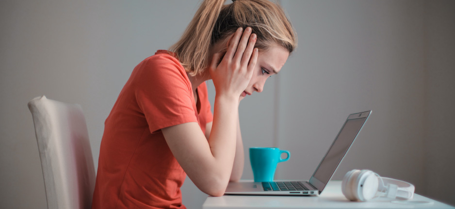 stressed woman looking at computer screen